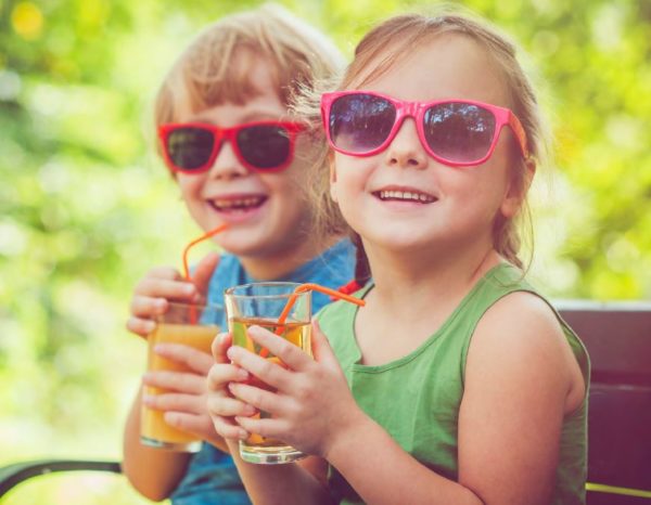 Image of two kids in sunglasses holding drinks
